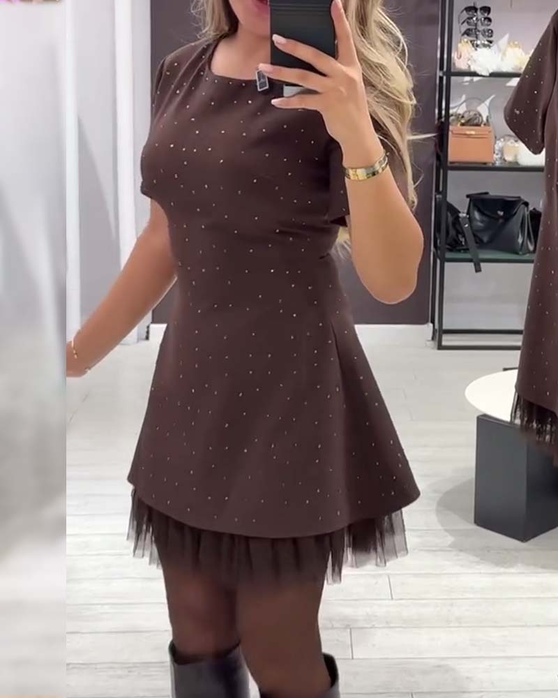 An elegant dress with a shimmering mesh patchwork design.